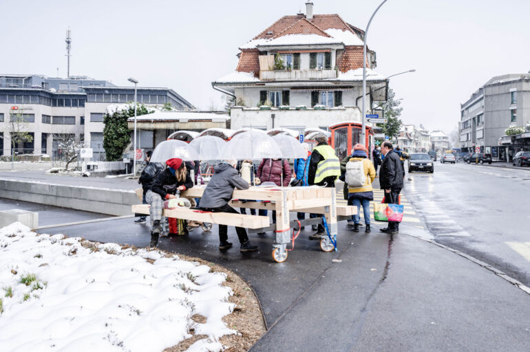 Zweite Station des Rollenden Tisches beim Bahnhof Ostermundigen auf dem Platz vor der Migros: Intensive Diskussionen bei Schneetreiben, Bild: Susanne Goldschmid